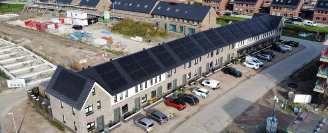 Lange rij nieuwbouwwoningen met zonnepanelen op het dak in een wijk