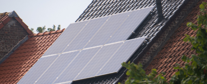 Een rijtjeshuis met rood dak met daarop zonnepanelen voor duurzame energie.